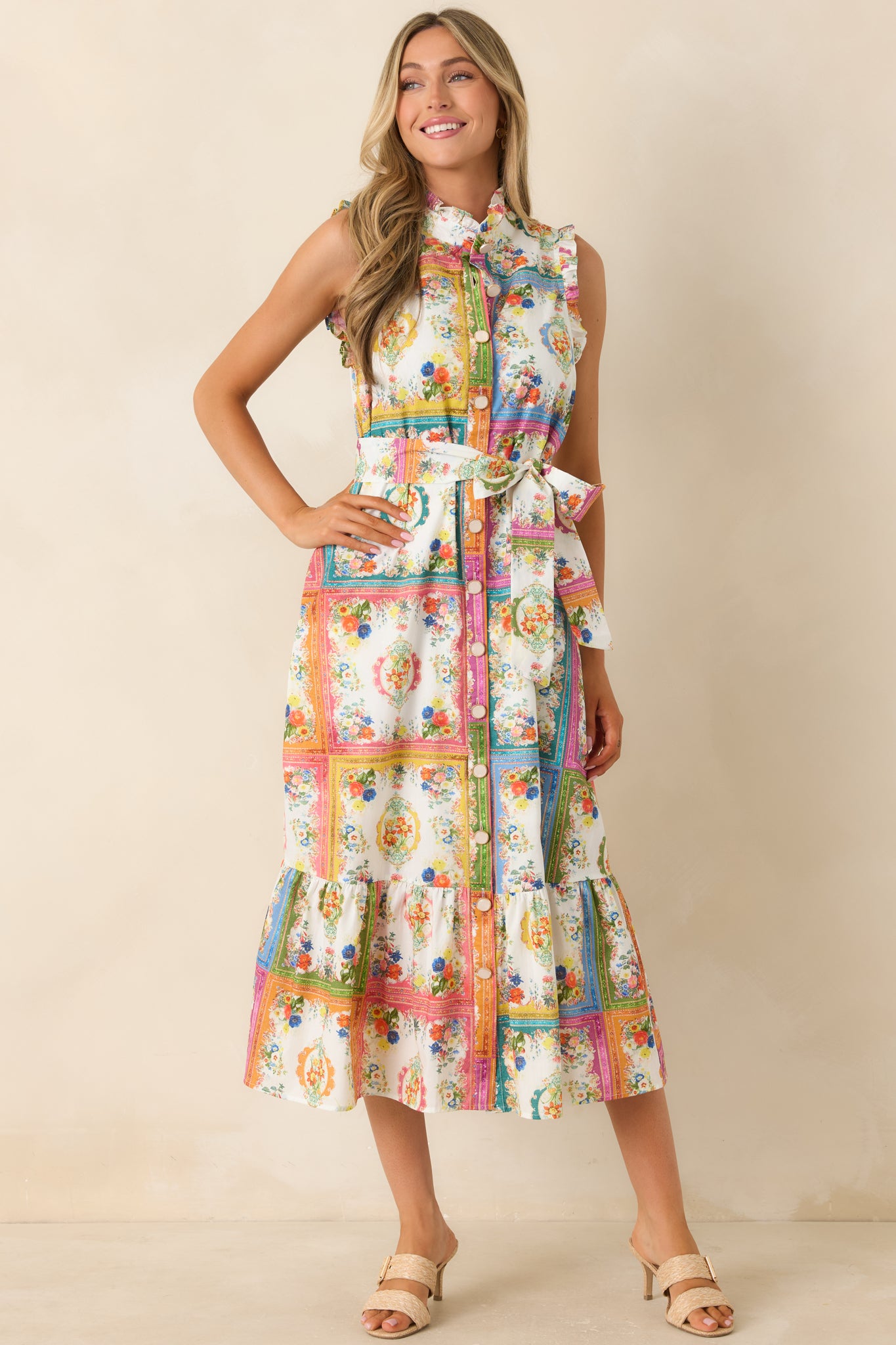 Multi floral tile print midi dress featuring a button front closure, ruffled neckline trim, removable waist tie, and functional side pockets in 100% cotton.

