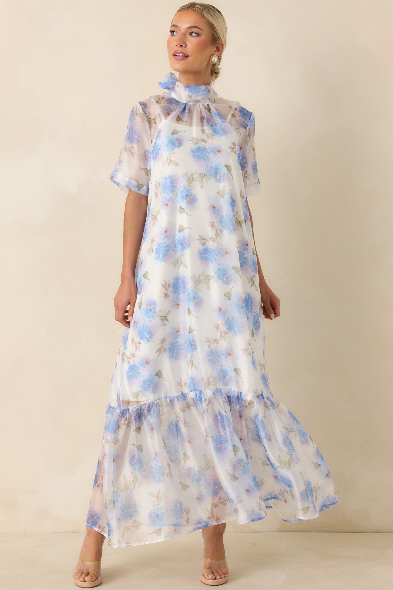 Flowing blue floral maxi dress featuring a sheer finish, relaxed silhouette, and delicate tiered skirt details.