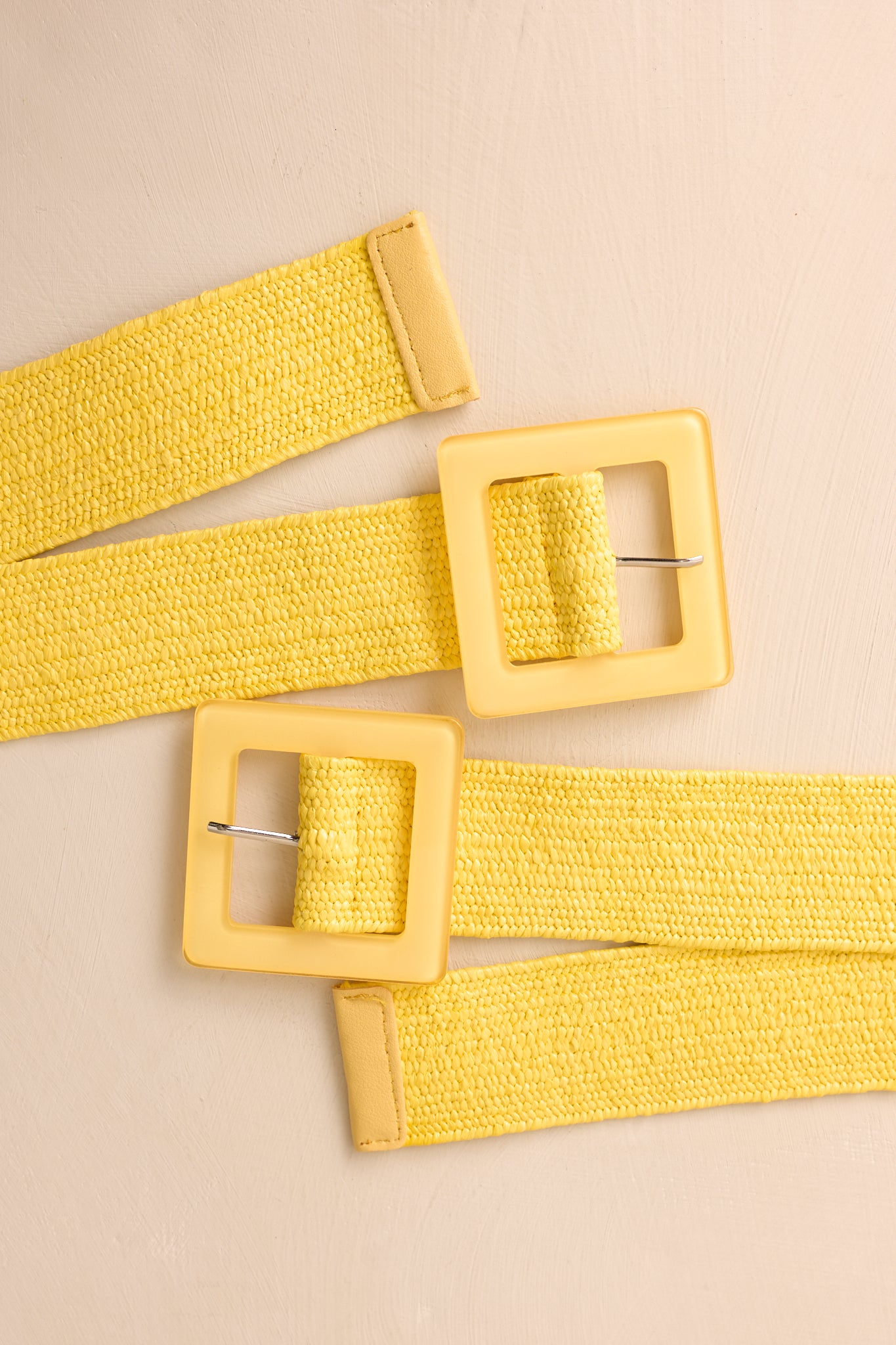 Back view of yellow woven belt displaying flexible elastic construction and adjustable pin closure.
