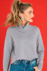 Front view of this sweater that features a chunky cowl neckline accompanied by ribbed detailing, straight long sleeves completed by ribbed cuffs, and a straight hemline.
