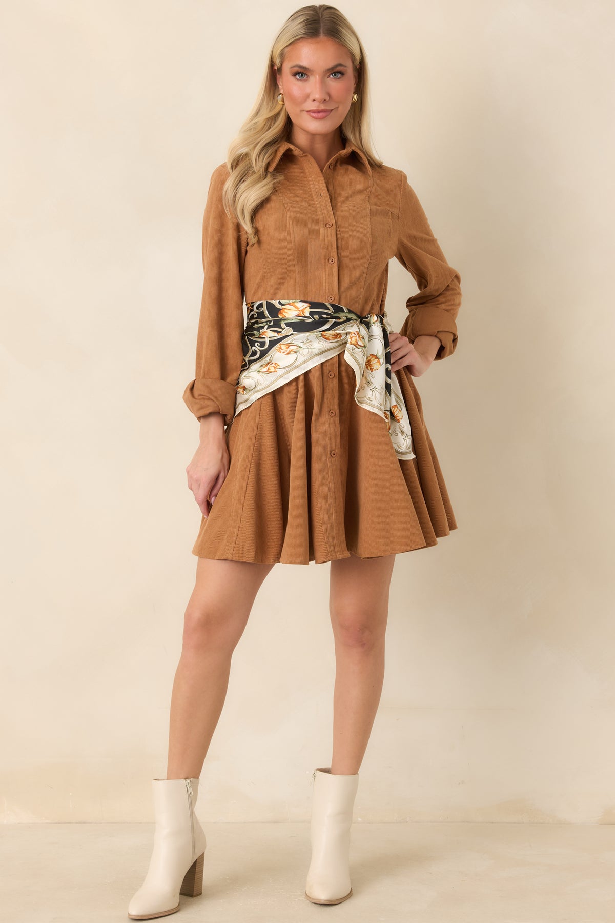 Golden camel corduroy mini dress with a pointed collar, button-front closure, and inset skirt panels creating a softly flared shape.