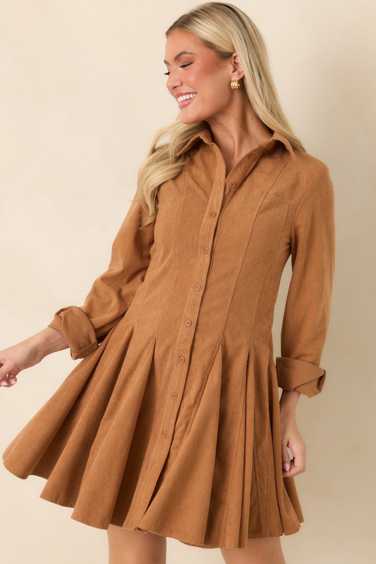 The camel corduroy mini dress showcases its full button front and fine ribbed texture across the bodice.