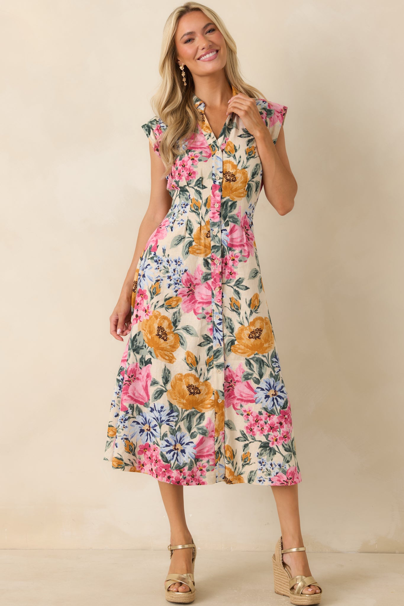 Linen and rayon blend midi dress showcasing a functional button-front design and a flowing midi-length shape covered in a multicolor floral pattern.
