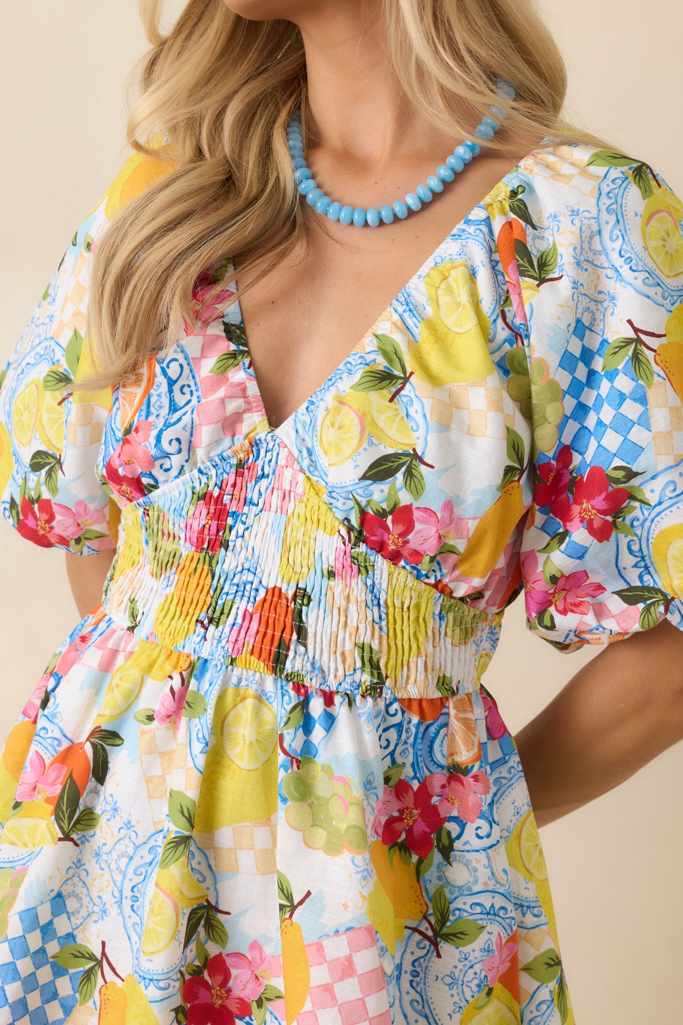 Close-up of the citrus fruit print with lemon and orange motifs set against a lightweight linen cotton blend fabric.