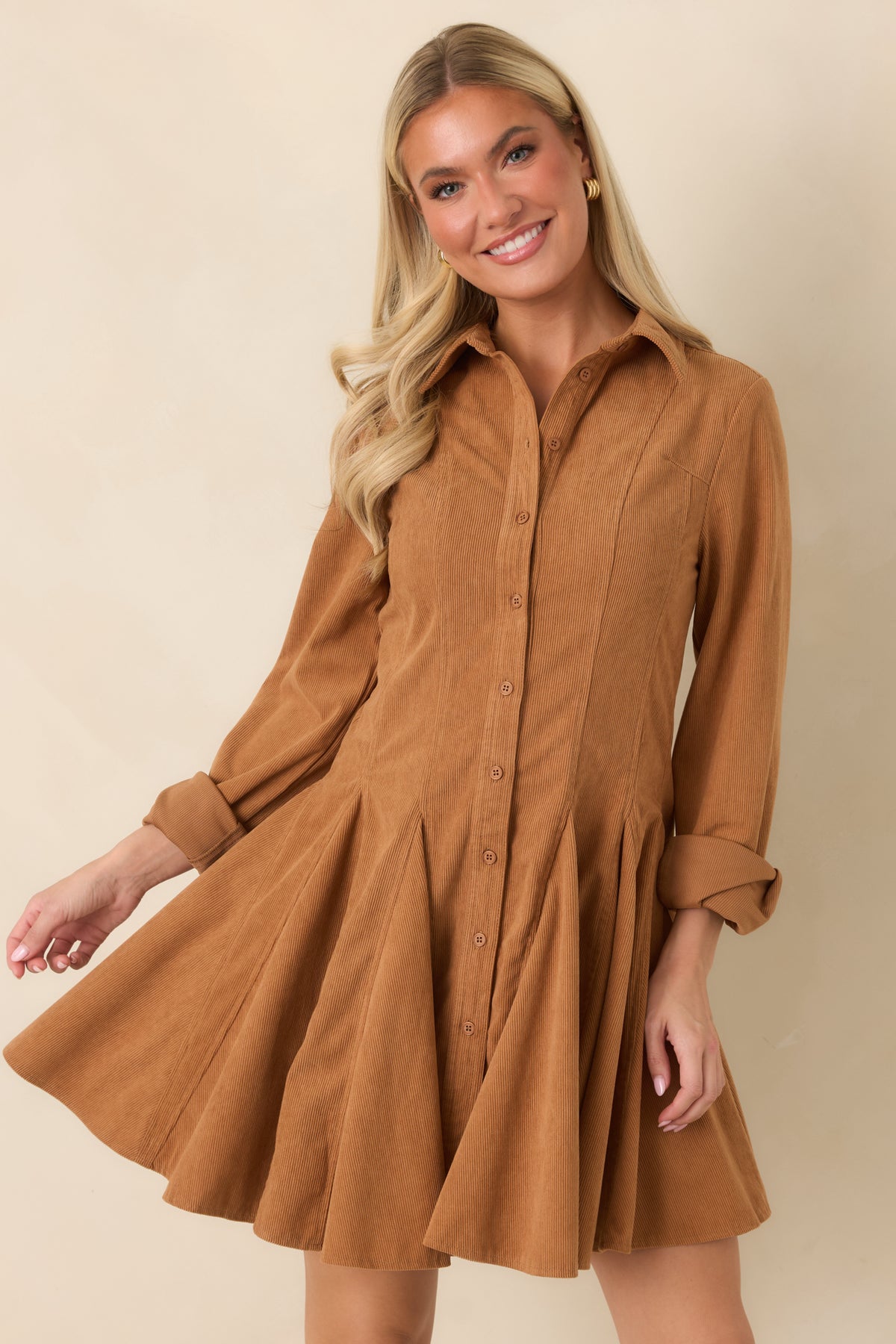 Shaping seams define the bodice before transitioning into the flared skirt of the camel mini dress.