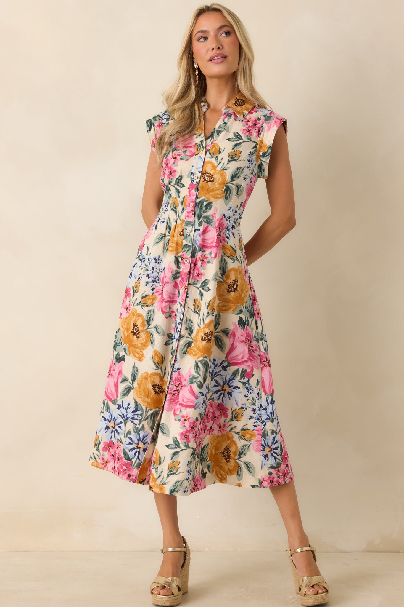 Ivory multi floral midi dress highlighting its structured button-front closure and gently shaped silhouette through the waist and skirt.