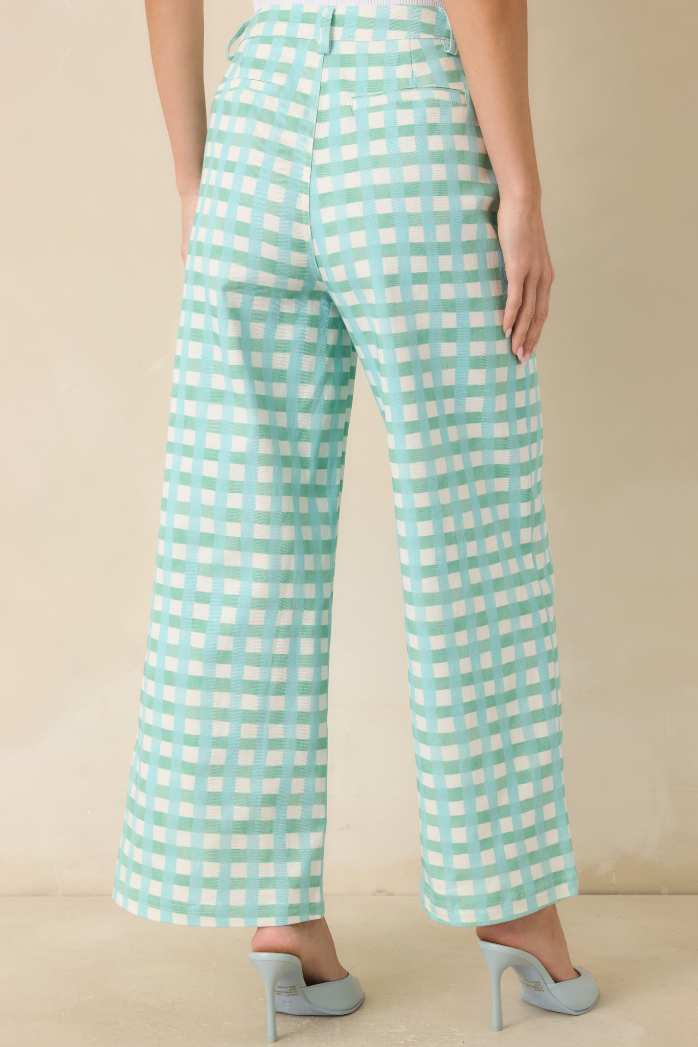 Rear view of aqua blue and mint gingham pants featuring a high-rise waistband, belt loops, and a flowing wide-leg silhouette.