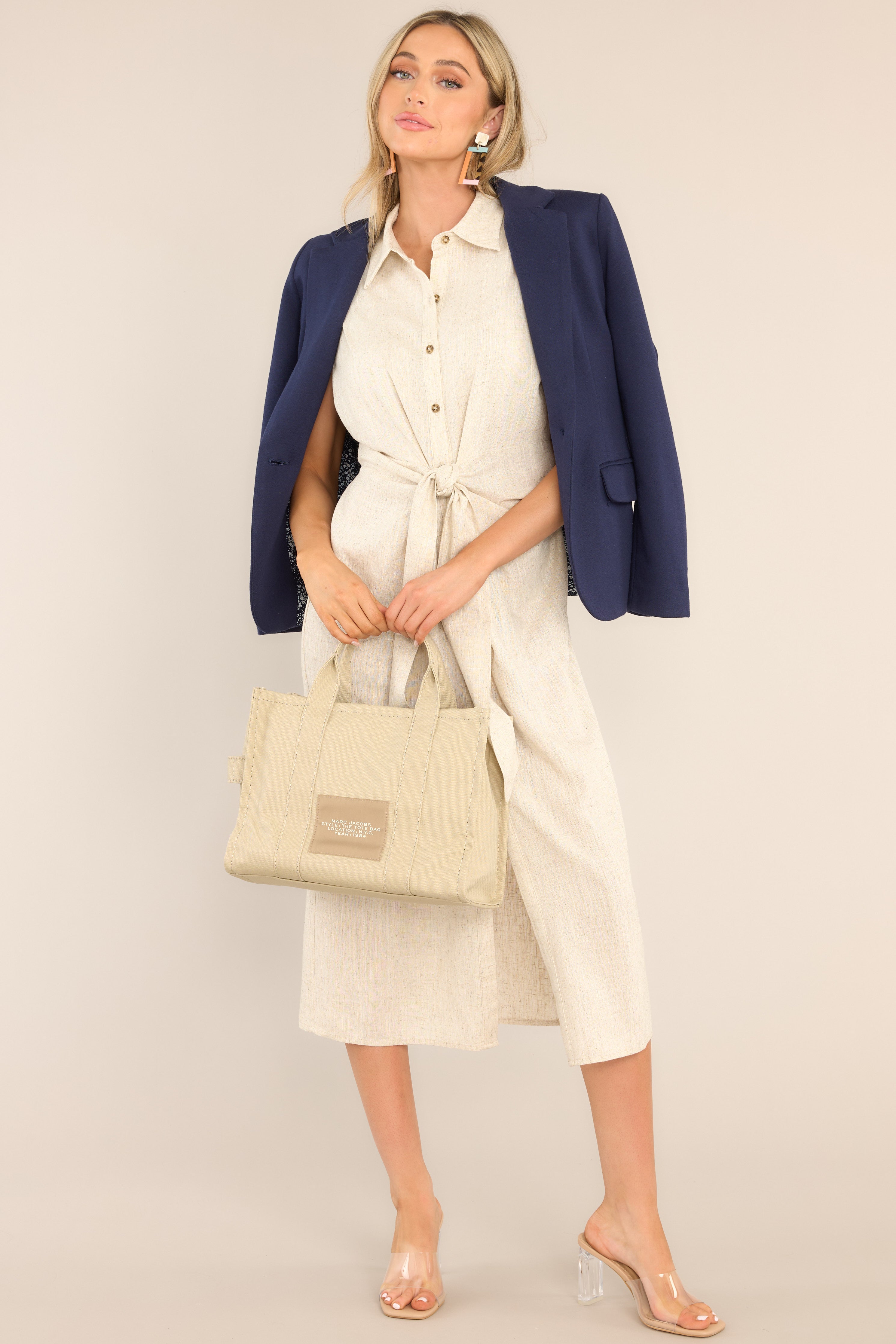 Navy Blazer, styled draped over the shoulders of a sleeveless tie dress. 
