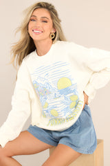 This ivory sweatshirt features a crew neckline, dropped shoulders, a summery graphic, ribbed cuffed sleeves, and a ribbed hemline.