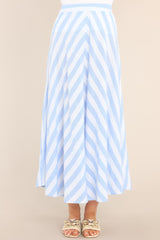 Close up view of  this skirt that features a high waisted design, a functional zipper and hook closure in the back, a diagonal striped pattern, and a flowy fabric.