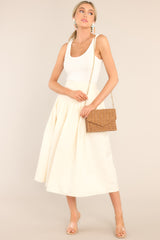 This ivory skirt features a high waisted design, an elastic insert at the back of the waist, and intricate pleats around the hipline.
