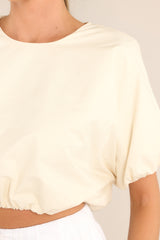 Close up view of this top that features a crew neckline, elastic cuffed dolman sleeves, and an elastic cuffed cropped hemline.