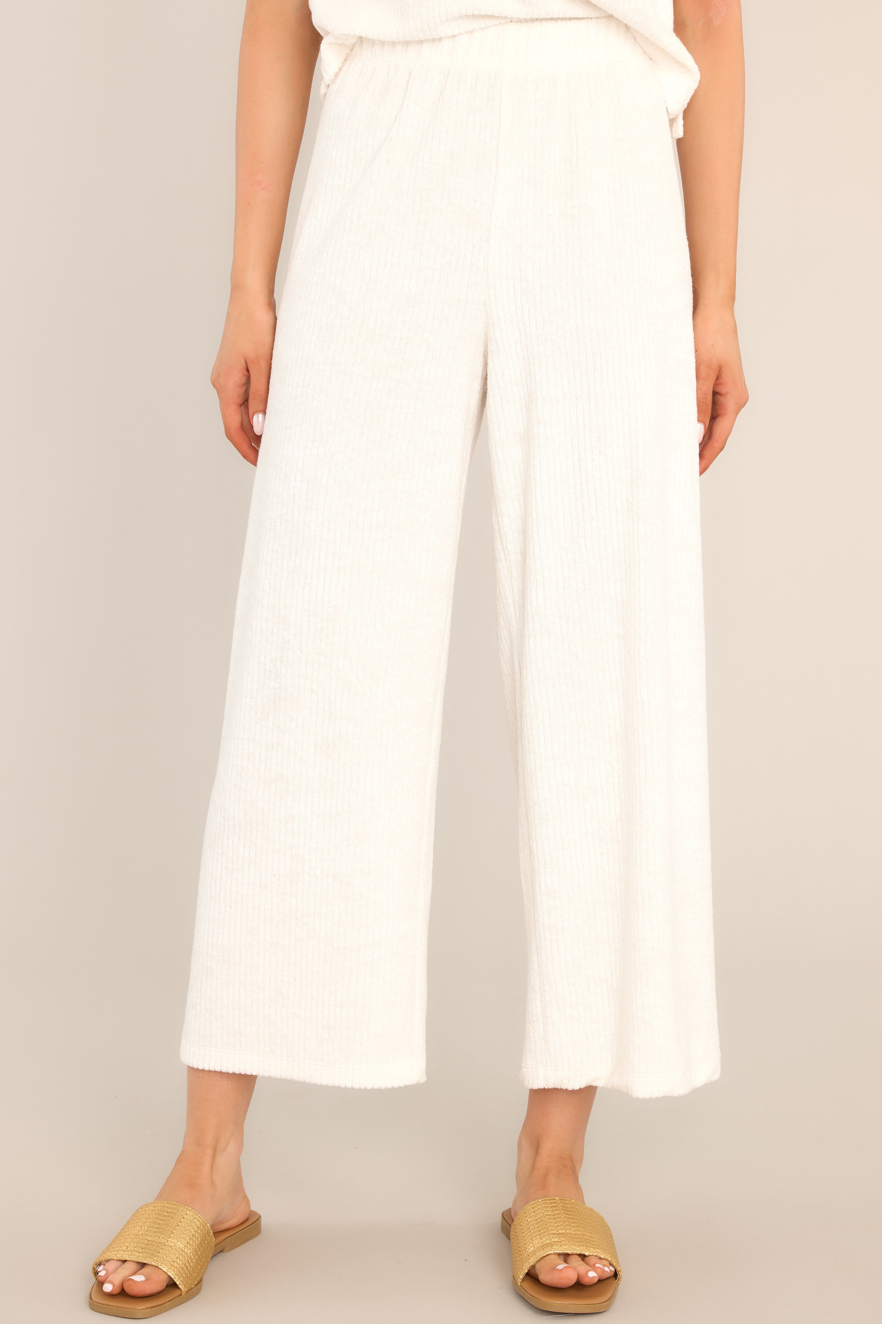 Front view of these pants that feature a high waisted design, an elastic waistband, ribbed terry cloth, and a slightly cropped hemline.