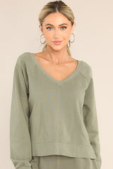 Front view of this sweatshirt that features a ribbed wide v-neckline, an intentional front-seam detail, fitted ribbed sleeve cuffs, and a small split hem on the sides.