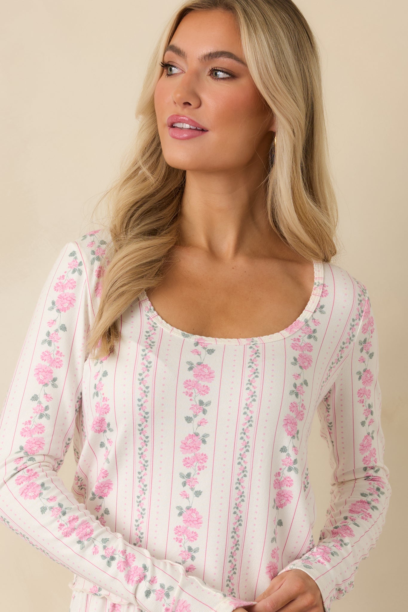 Front detail of the ivory knit top featuring floral stripe accents and a smooth, stretchy texture.