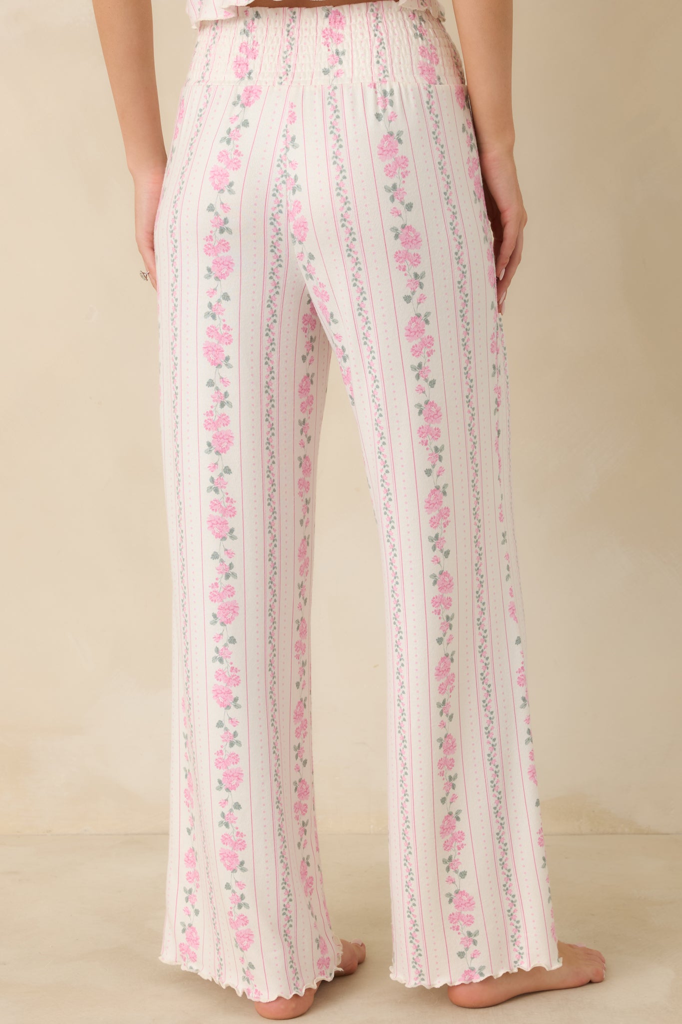 Ivory floral stripe pants shown from the rear, highlighting the smocked elastic waistband and straight-leg drape.