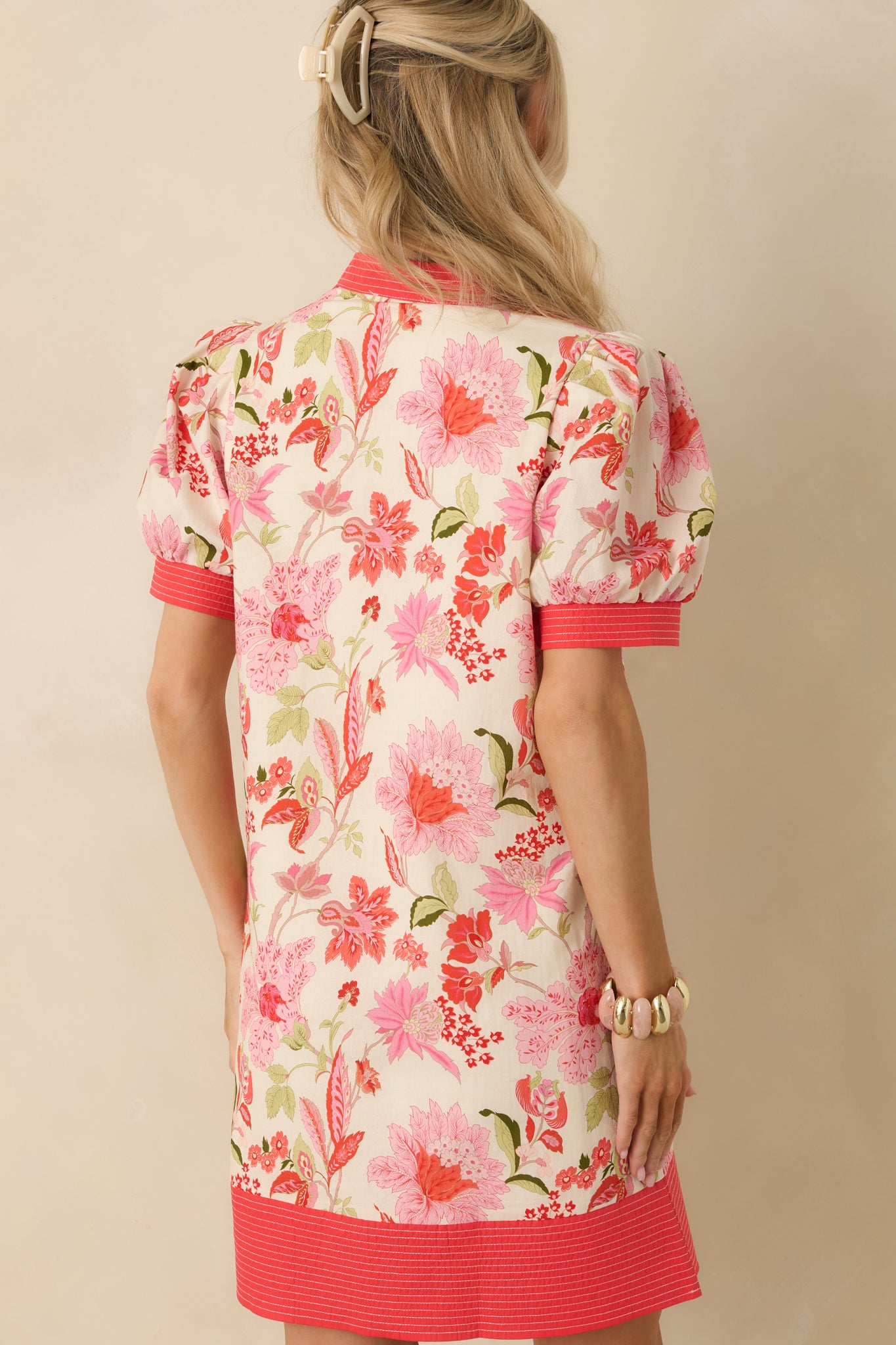 Coral pink floral mini dress shown from the back, highlighting the straight shift silhouette and lightweight cotton fabric.