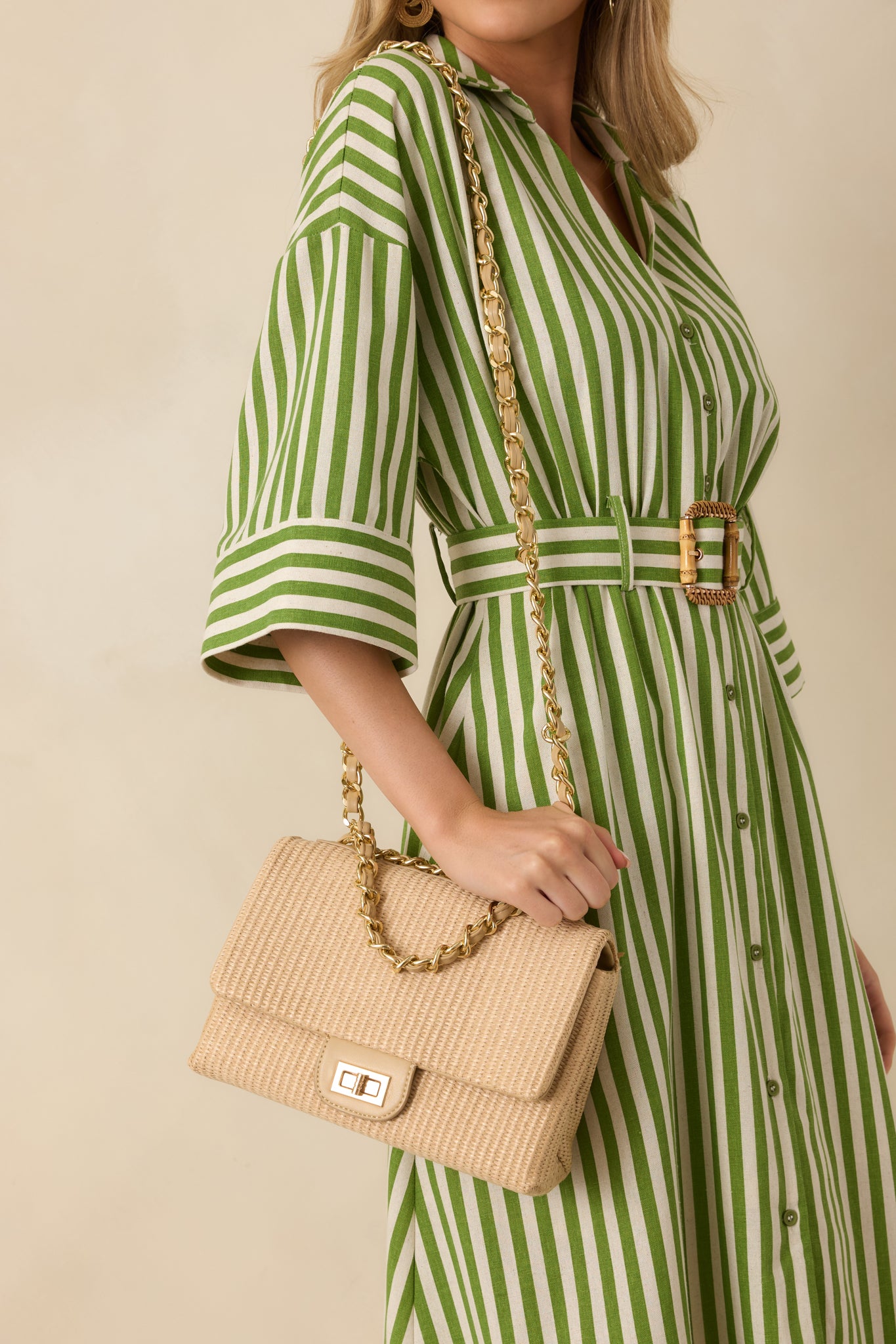 Angled full view of the tan handbag highlighting the top handle and optional gold chain shoulder strap.