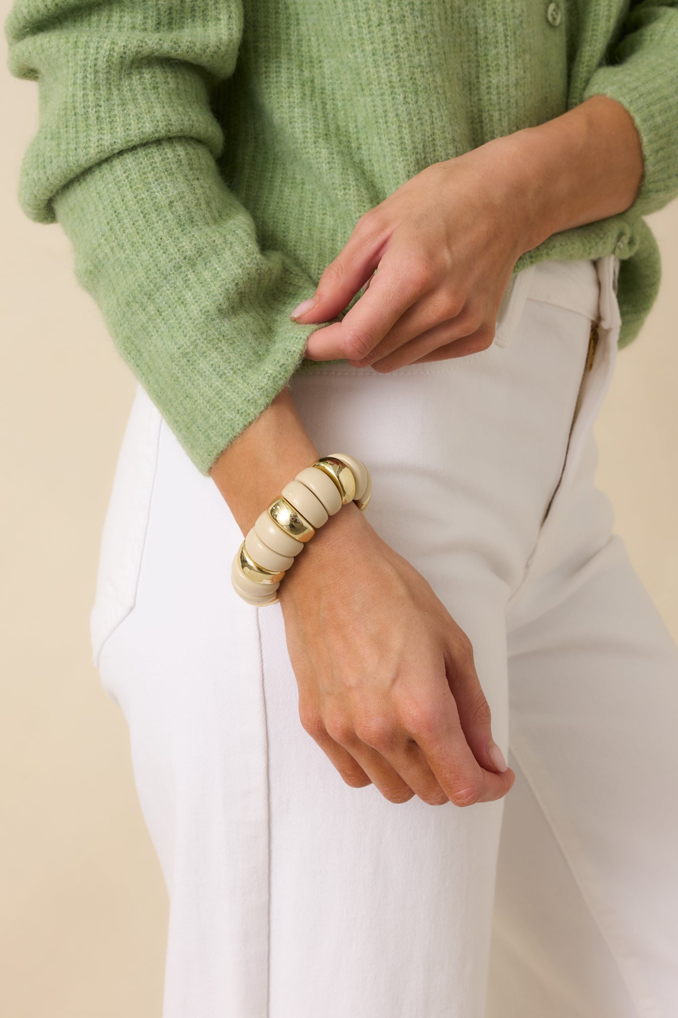 Cropped view of the ivory and gold beaded bracelet highlighting the sculptural ivory beads and polished gold accents.