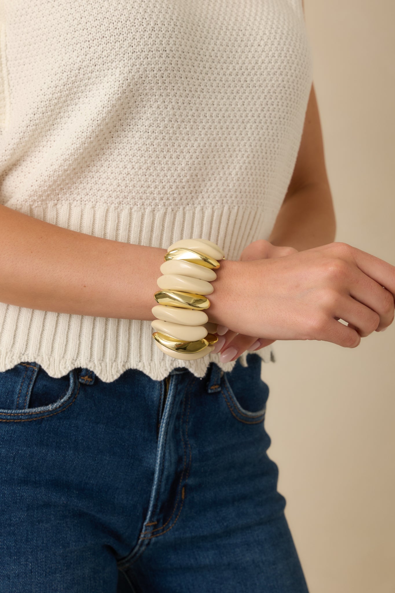 Cropped view of the stretch bracelet highlighting the sculptural ivory links and gold accent details.