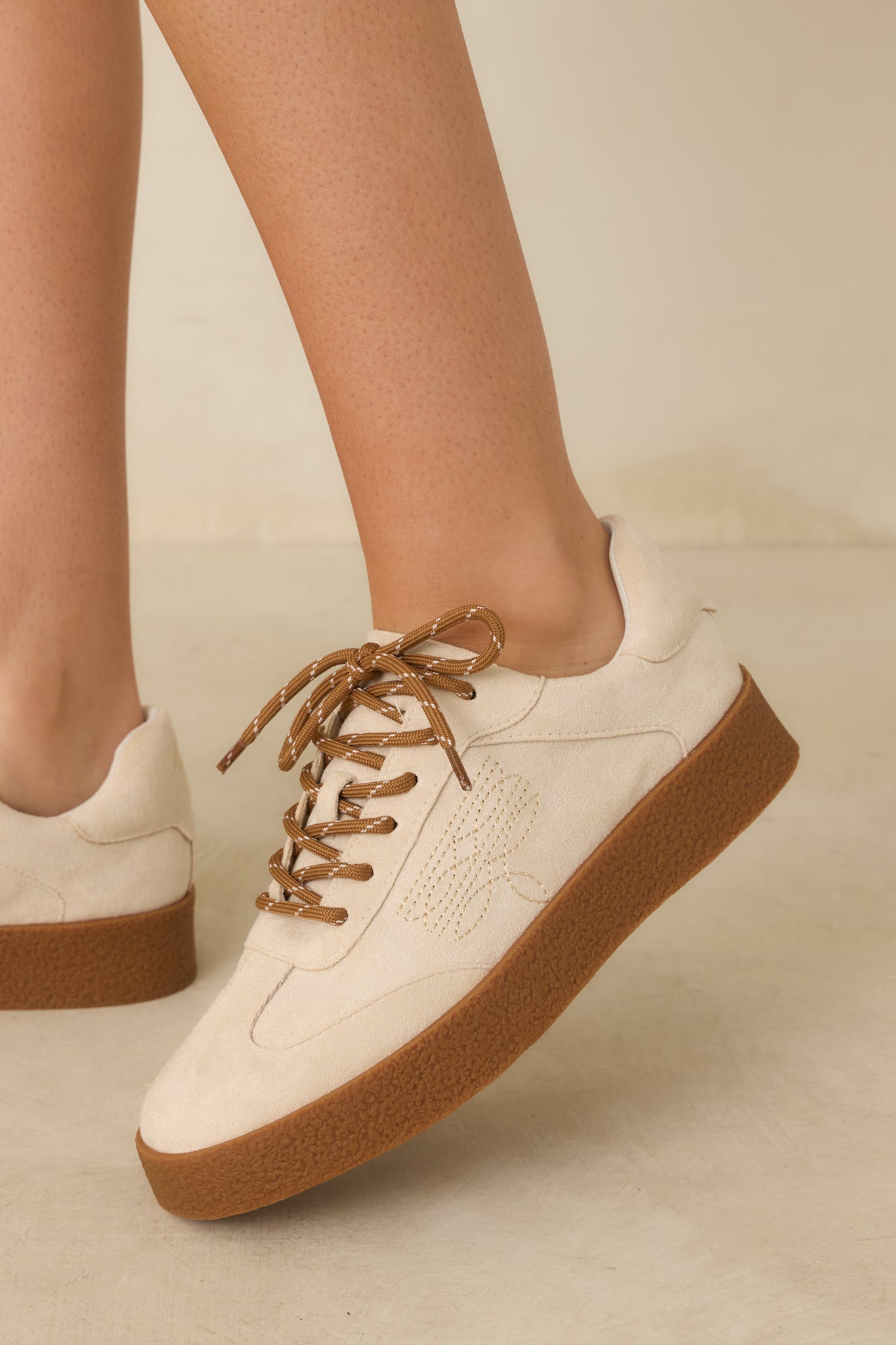 Cropped view focusing on tonal side stitching and smooth faux suede texture.