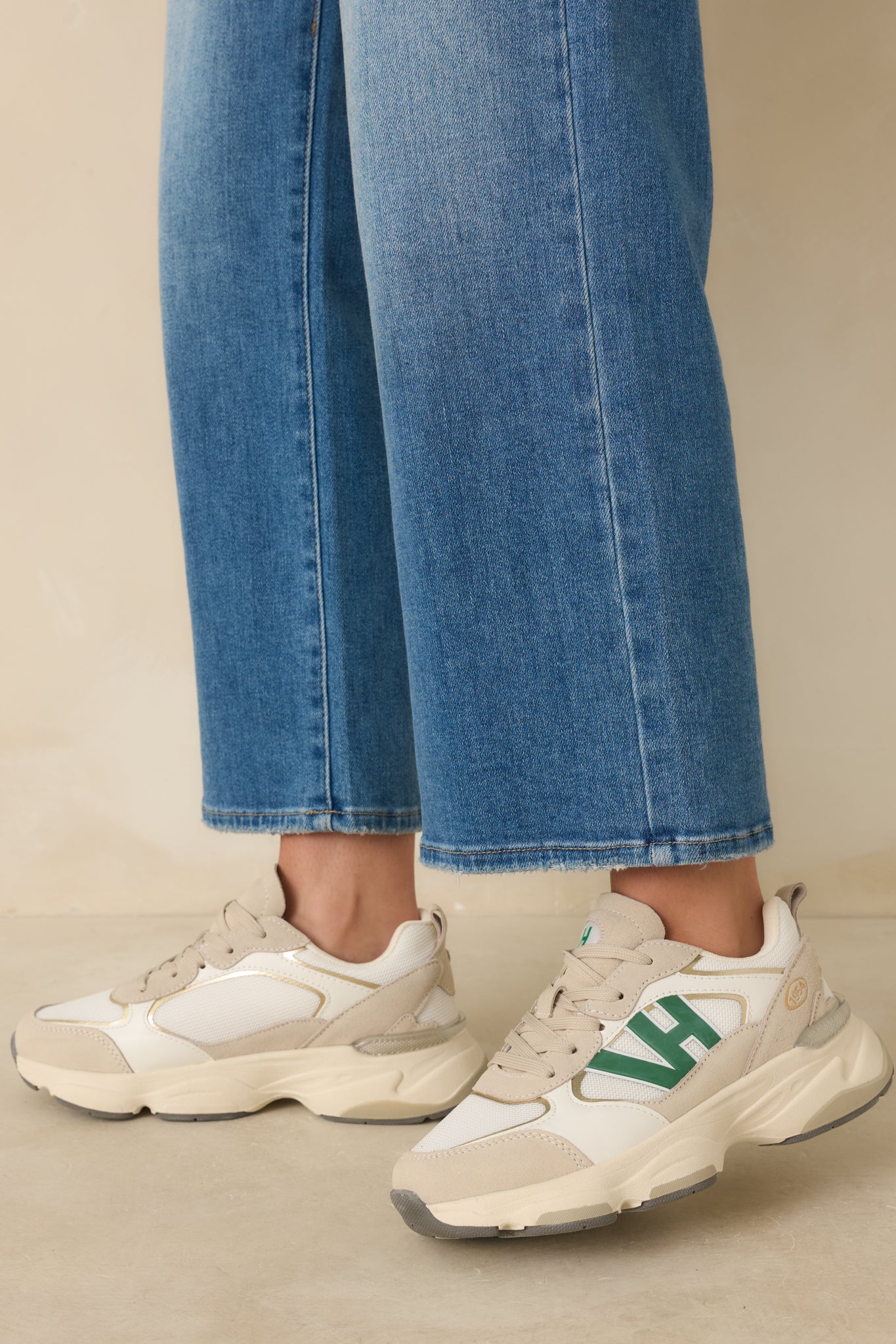 Green sneakers with rounded toes, thick beige soles with grey accents, and white and tan color blocking throughout.