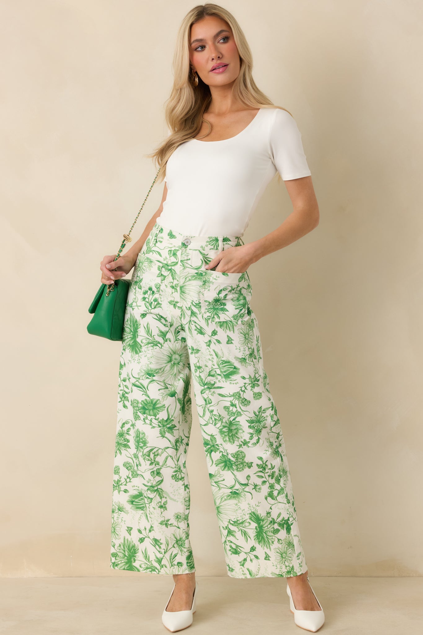 Full body photo of model wearing bodycon ivory top highlighting short sleeves and scoop neckline.