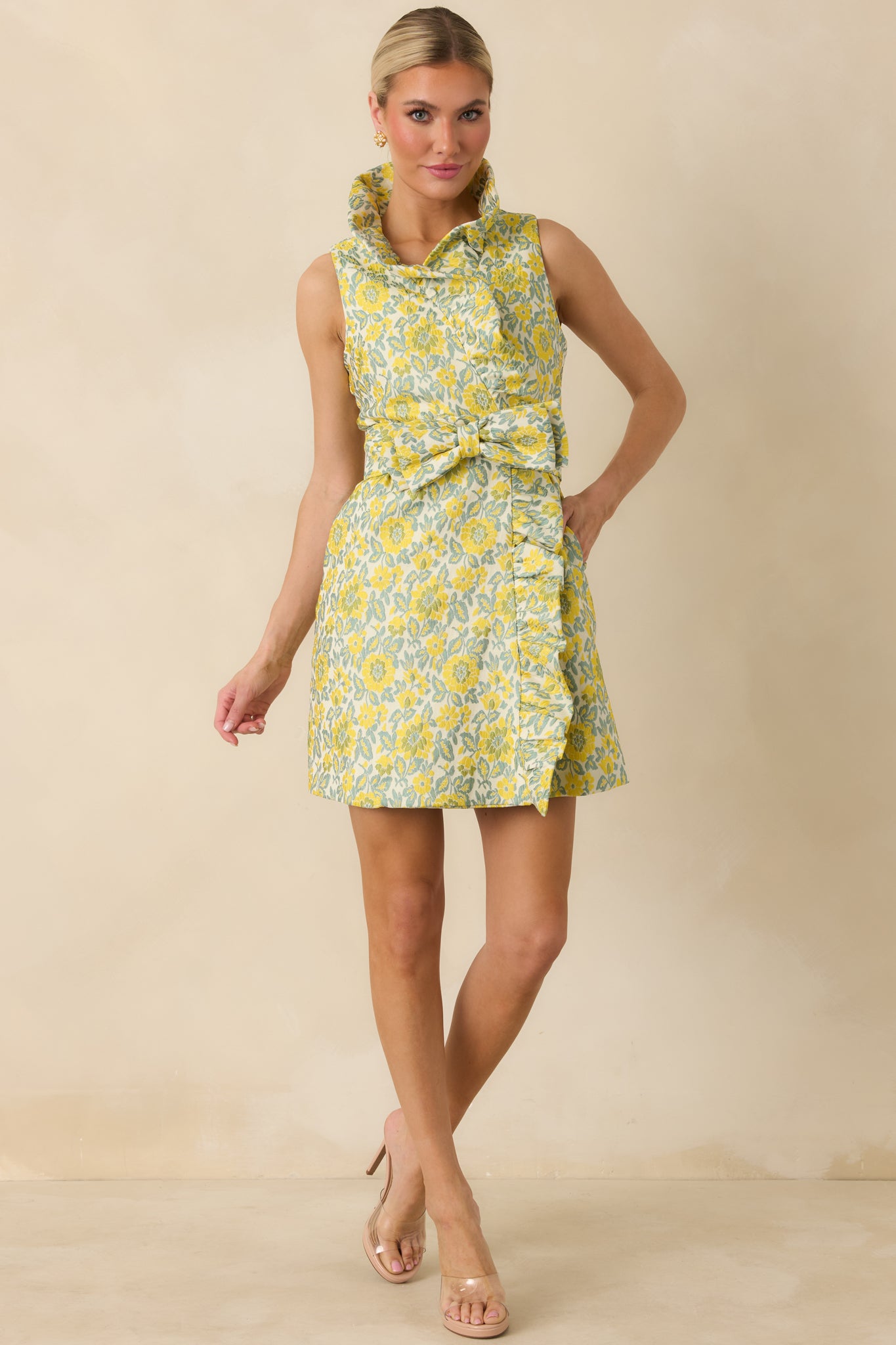 Flowing yellow mini dress with soft ruffled collar, faux wrap silhouette, and subtle textured jacquard fabric.