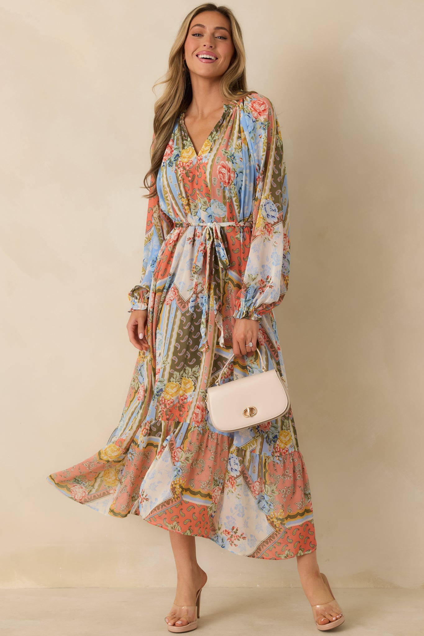 Multi floral print dress with V-neckline, ruffled collar, elastic cuffs, and ruffled bottom tier.