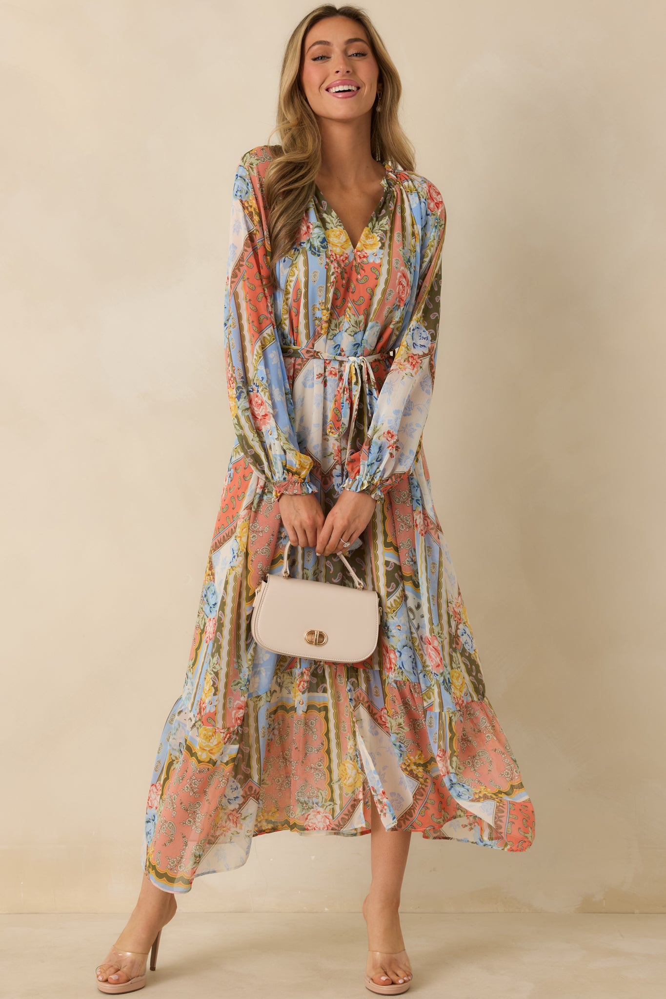 Front view of floral dress featuring self-tie belt with belt loops and flowing tiered hem.