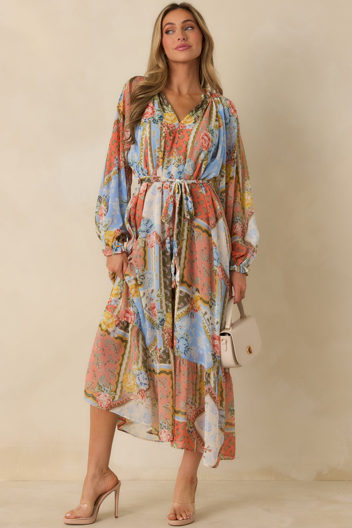 Multi floral dress with ruffled bottom, V-neck design, and cinched waist with belt.