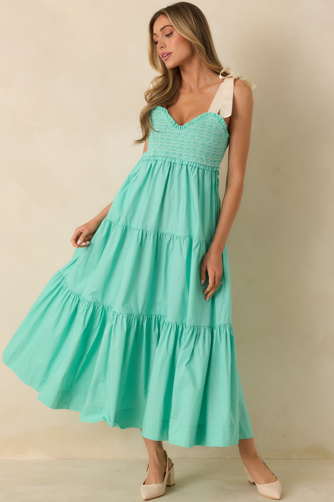 Front view of mint green midi dress featuring white embroidered detailing and fitted smocked bodice.