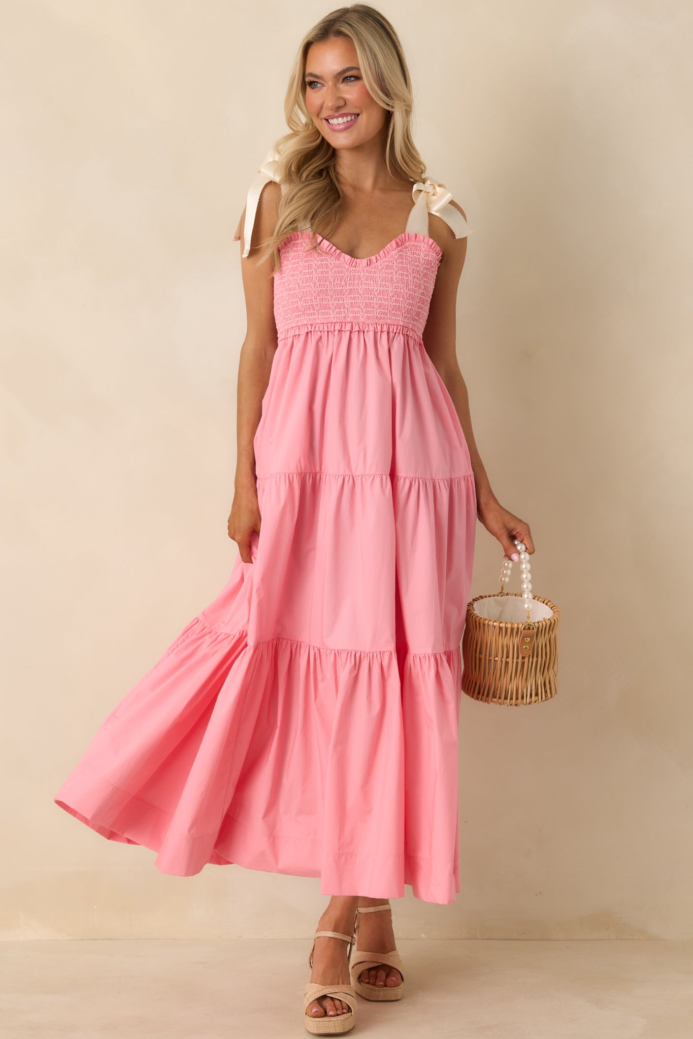 Pink coral midi dress with sweetheart neckline, smocked embroidered bust, and ivory self-tie bow straps.