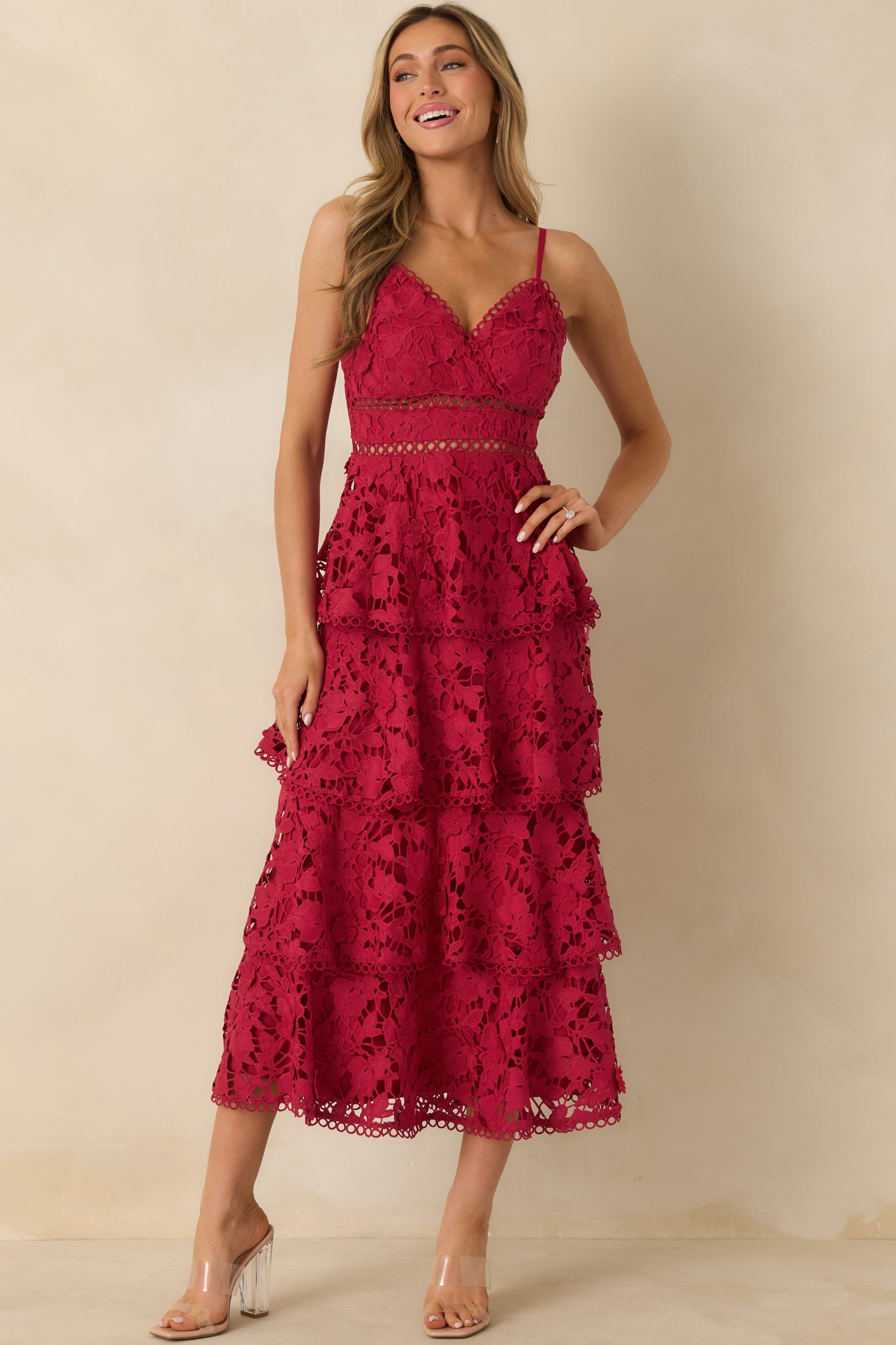 Flowing red maxi dress with V-neck, tiered lace panels, and subtle waist cutouts.