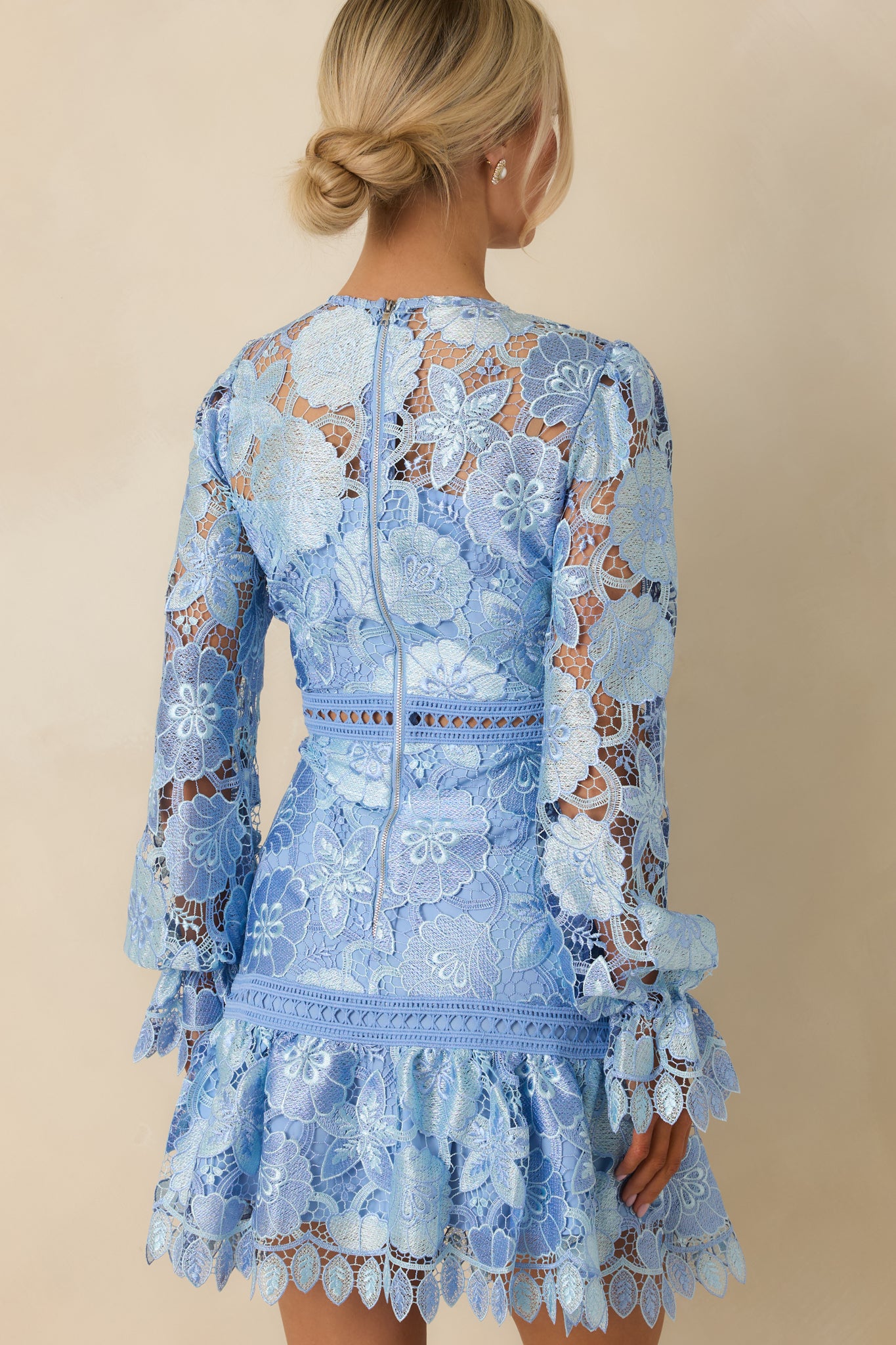 Rear view of mini dress featuring zipper closure, elastic cuffed sleeves, and subtle transparent accents.