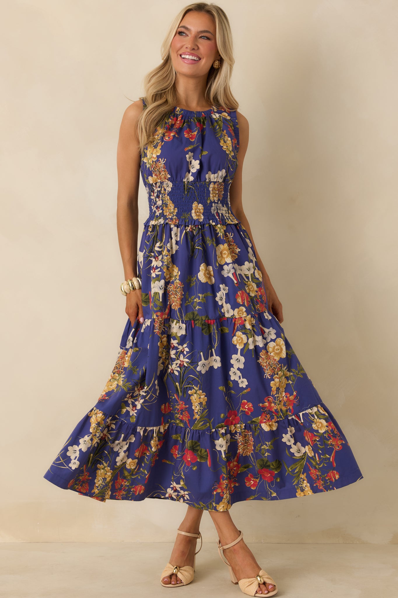 Flowing cobalt blue maxi dress with tiered skirt, smocked waistband, and colorful floral print for comfortable wear.