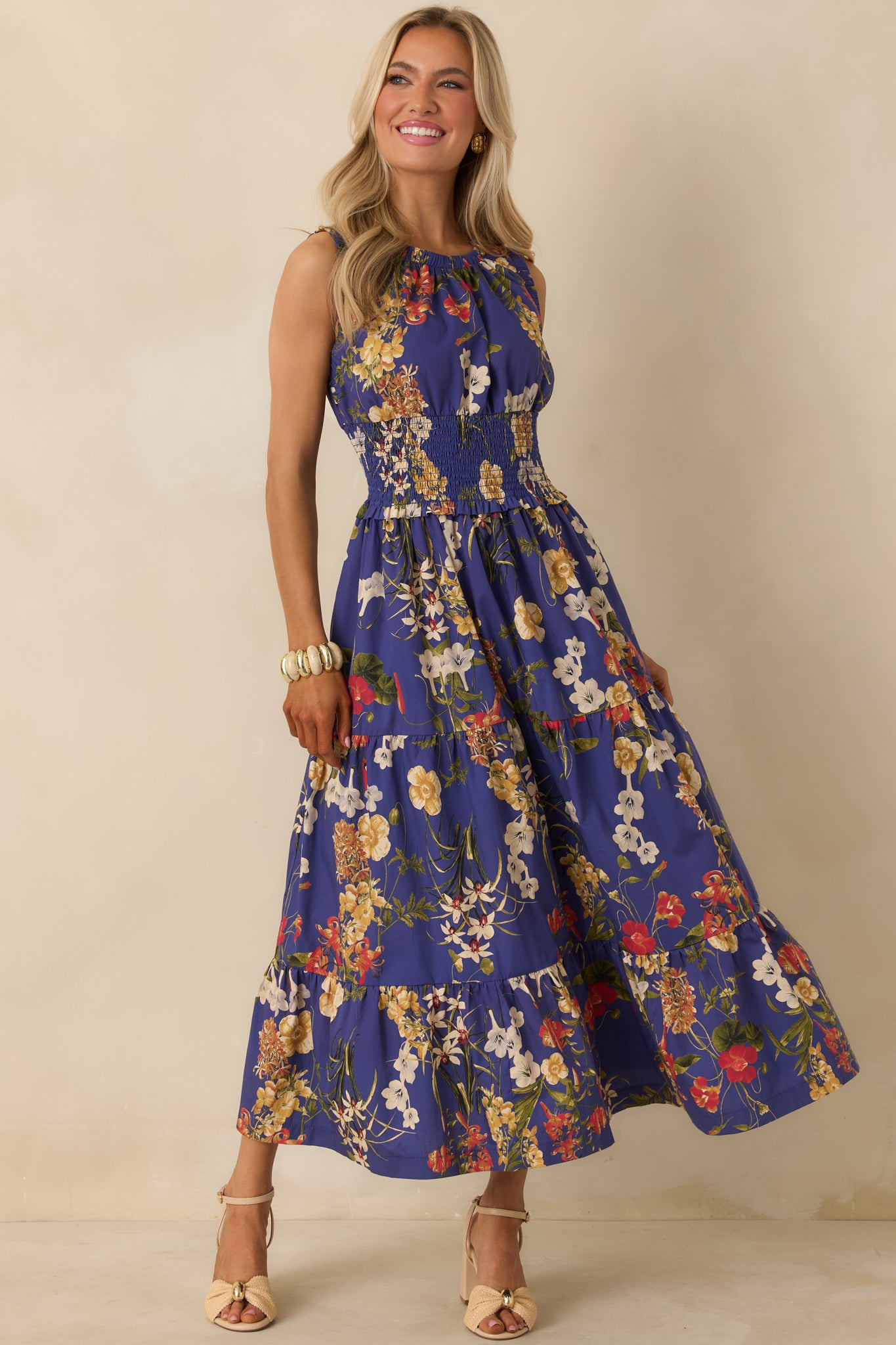 Cobalt blue floral maxi dress with lightweight cotton fabric, gathered neckline, sleeveless design, and tiered movement-friendly skirt.