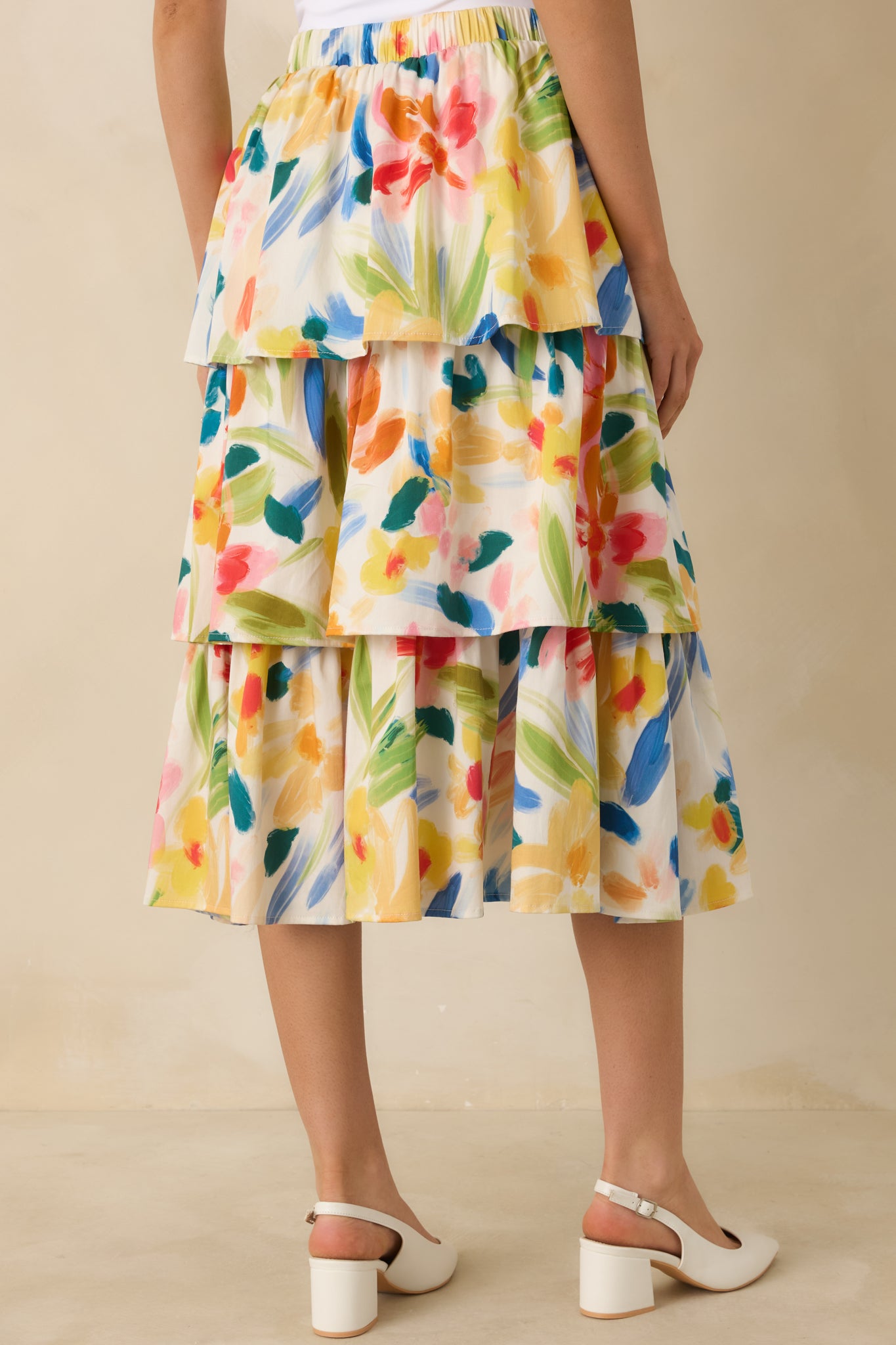 Rear view of the multicolored midi skirt showing the elastic waistband, tiered silhouette, and abstract floral print.
