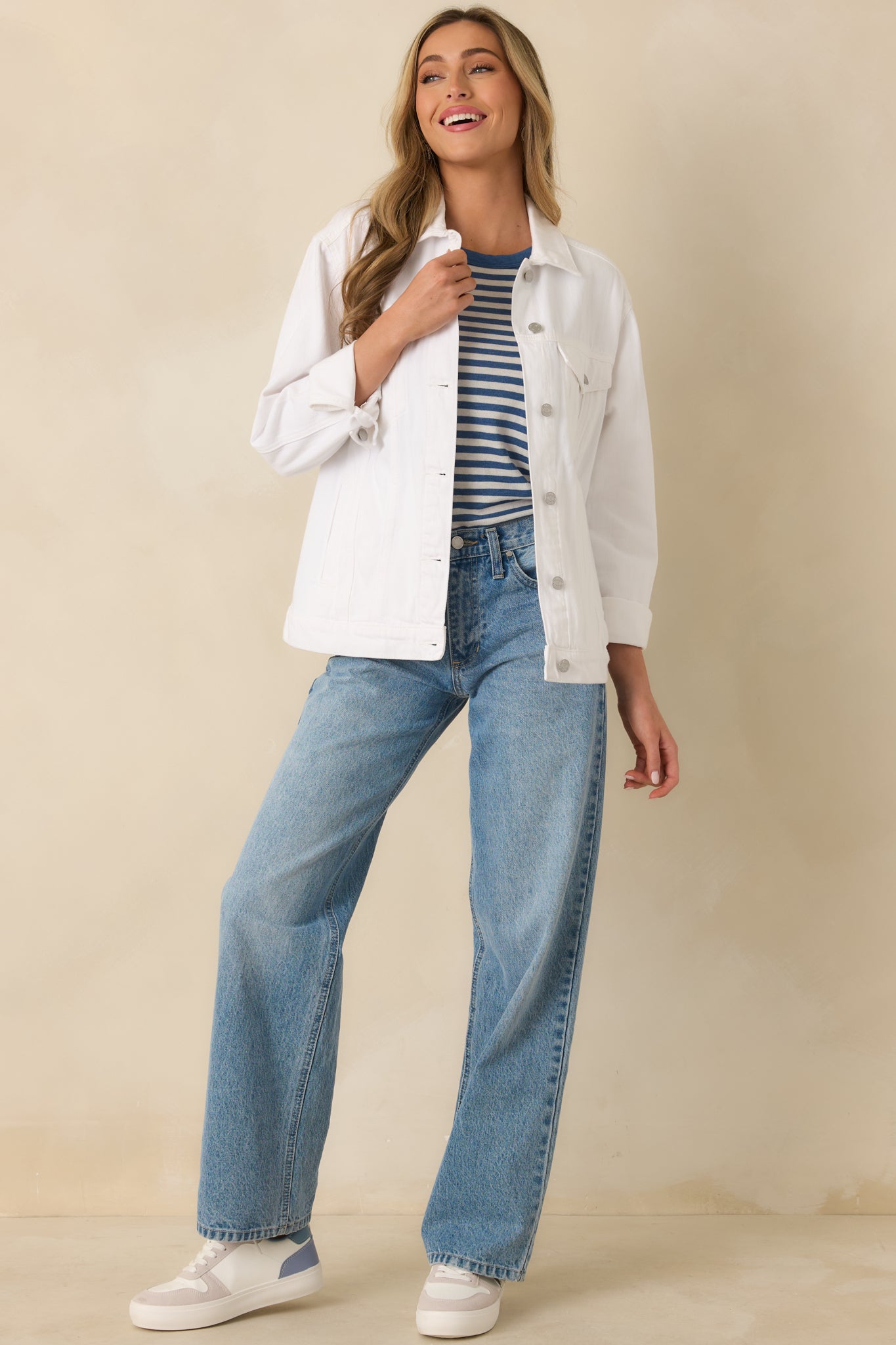 Angled front perspective highlighting the button sleeves and clean silhouette of the white denim jacket.