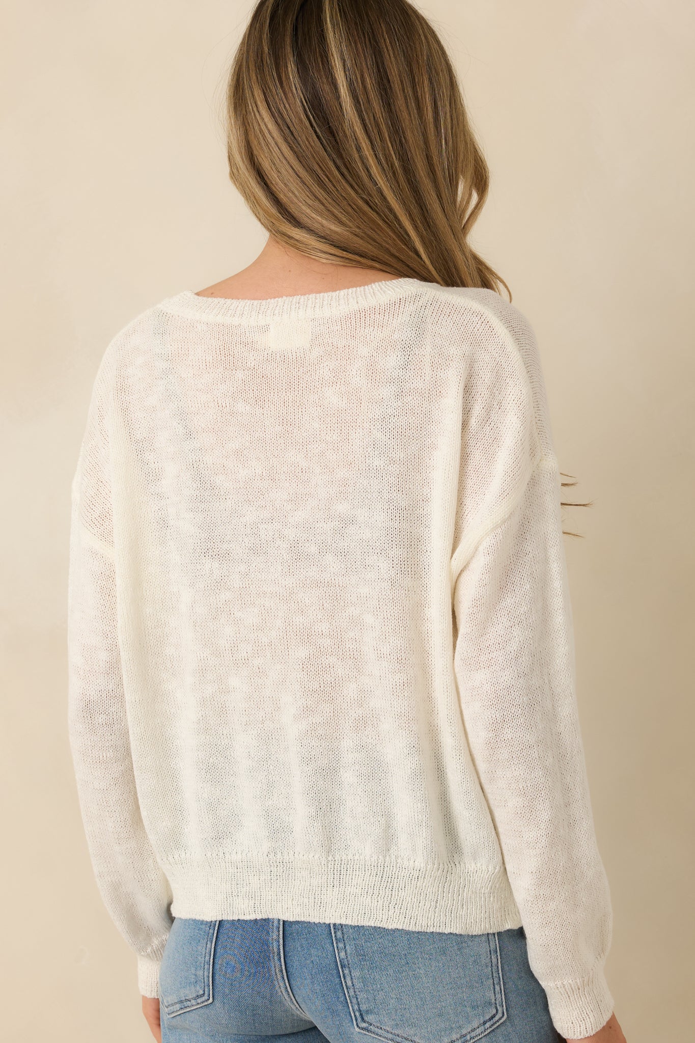 Back view of ivory knit sweater showing smooth knit fabric and relaxed silhouette.