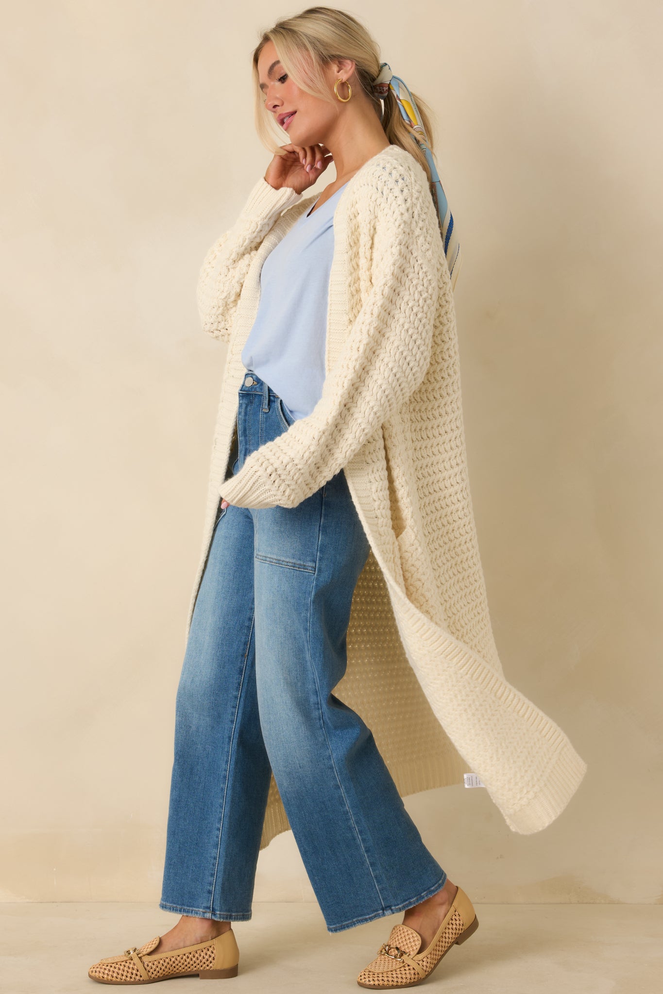 Chunky textured cream cardigan featuring front patch pockets and ribbed sleeve cuffs.