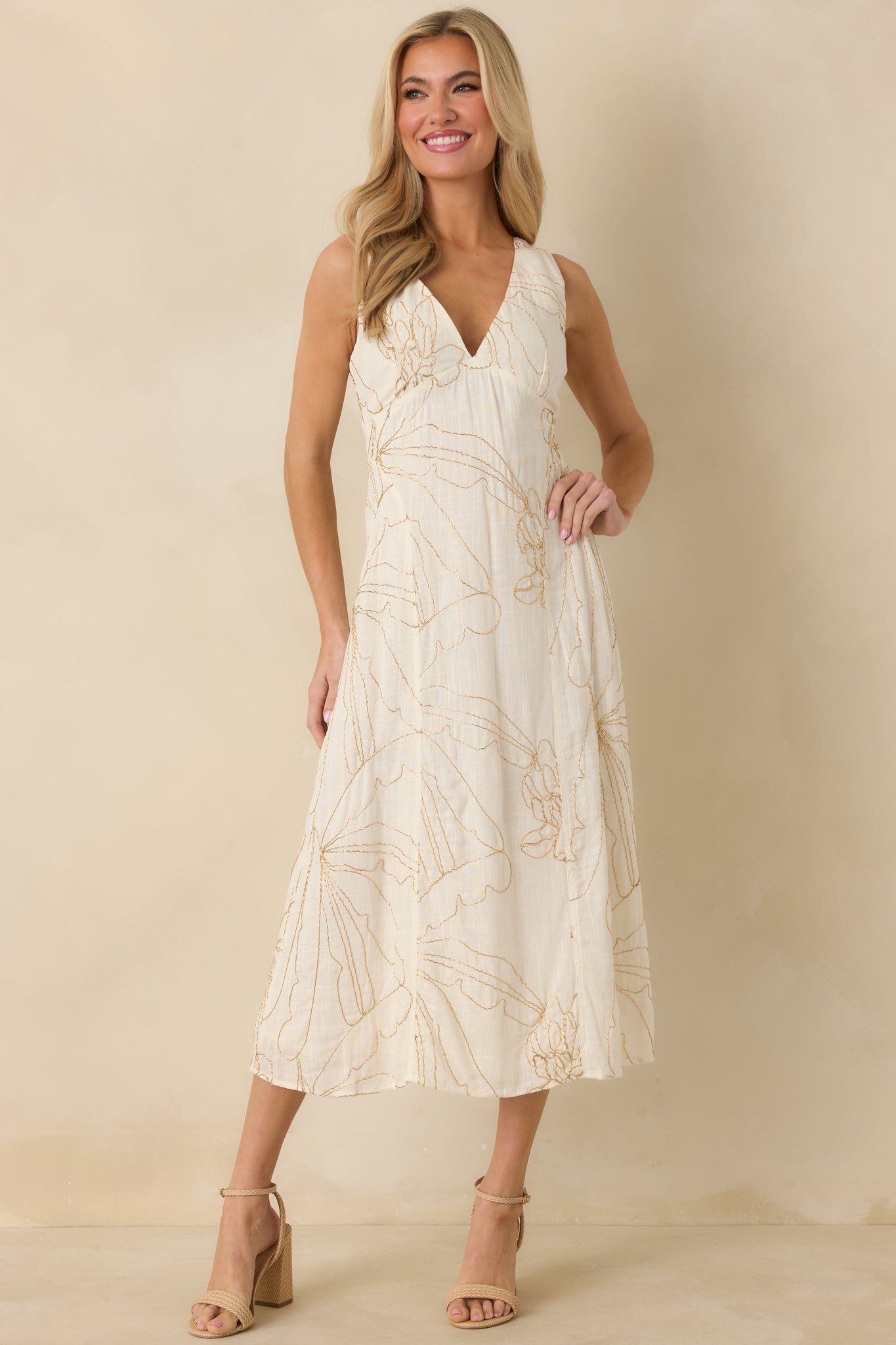 Ivory dress with golden beaded embroidery throughout, deep V-neckline, and a flattering fitted bodice paired with a flowy midi skirt.