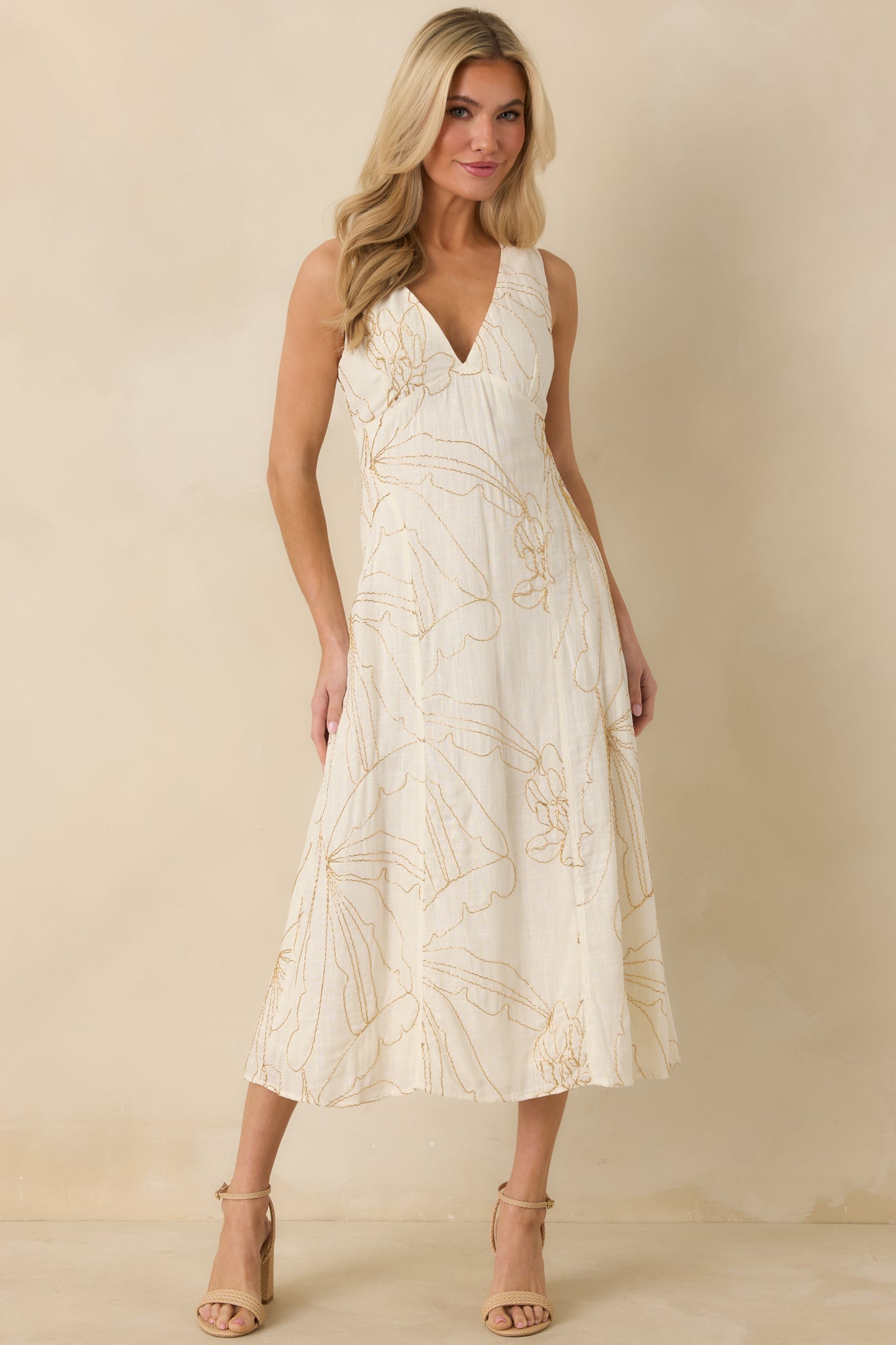 Flowy ivory midi dress showcasing gold floral bead details, a structured bodice, and a deep V-neckline for an elegant silhouette.