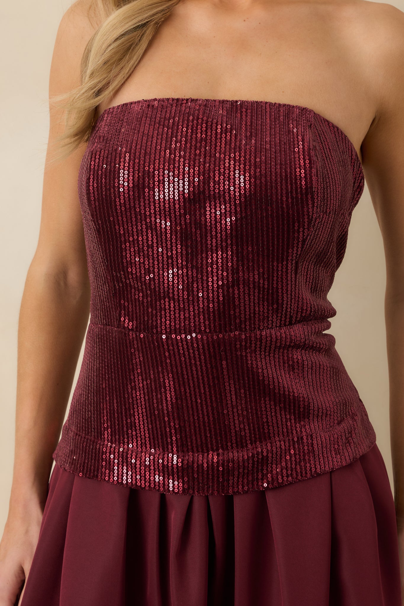 Close-up of the strapless sequin bodice with structured boning on the deep cherry red midi dress, highlighting the shimmer and texture of the fabric.