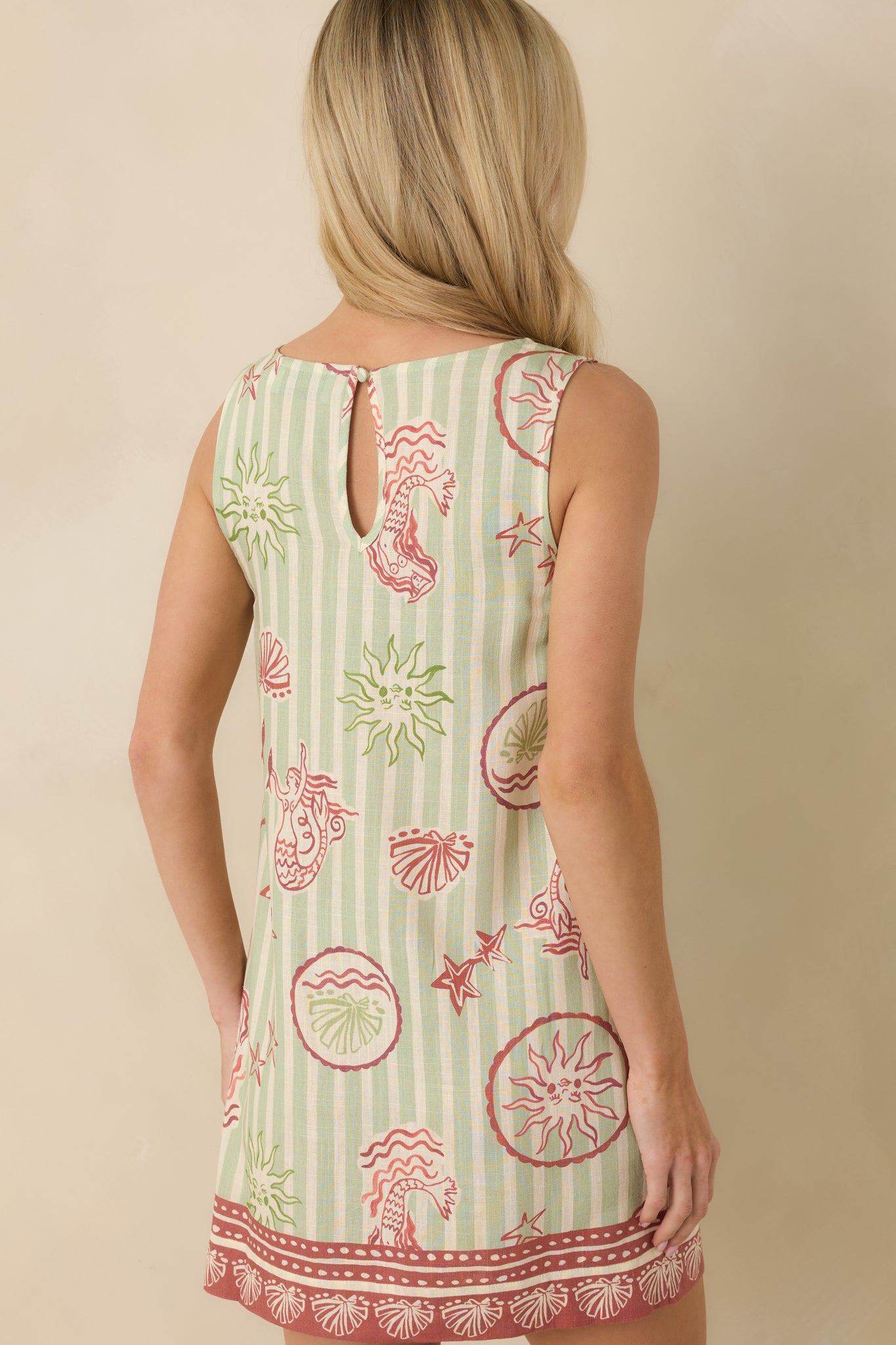Back view of the green stripe mini dress showing the subtle keyhole with button closure and sleeveless back.