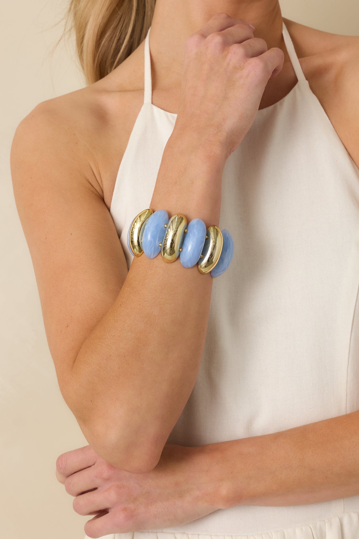 Close-cropped view of the two-row stretch bracelet highlighting the stone-like blue beads and polished gold accents.