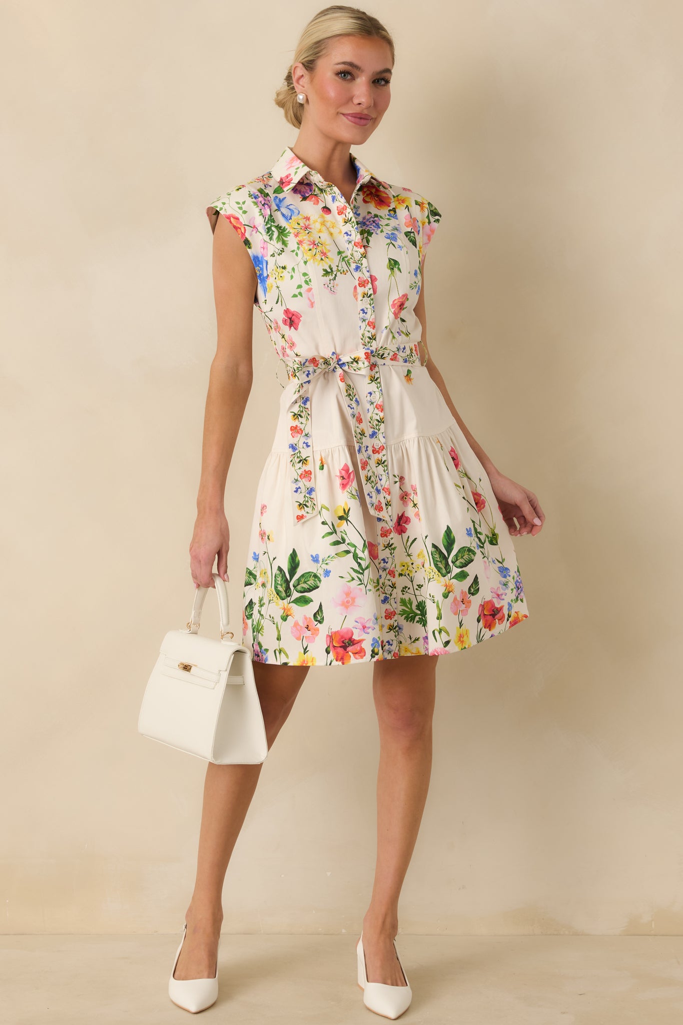 White multi floral mini dress with a collared neckline, button-front bodice, and softly flared skirt.