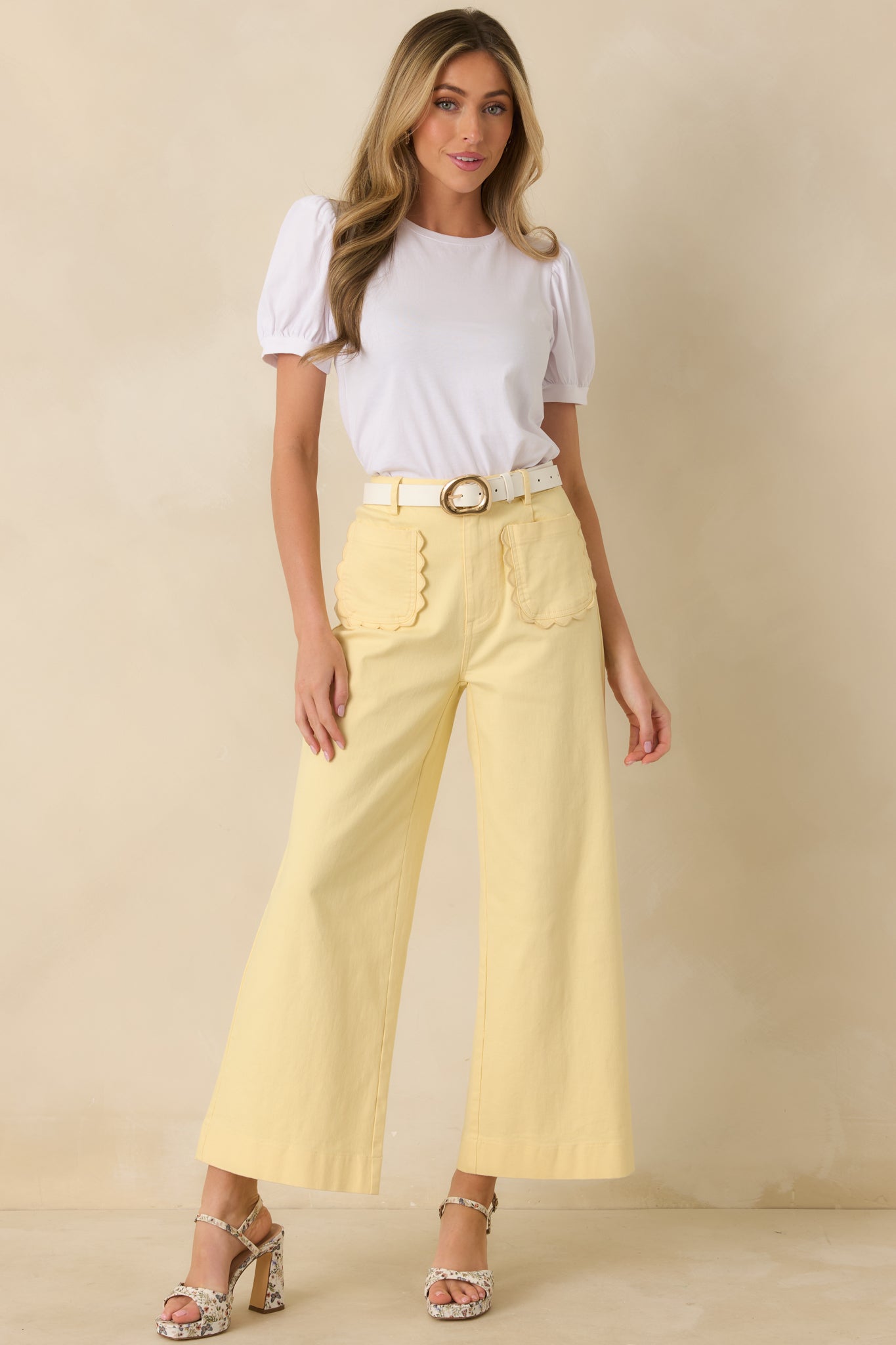 Bright yellow high-rise pants in a wide leg style with front button and zipper closure.