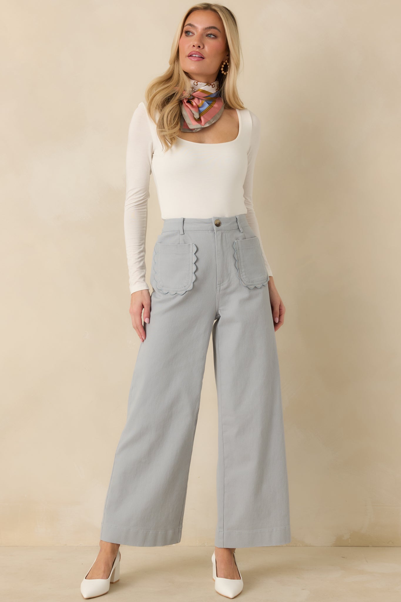 Dusty blue high-rise pants with wide leg silhouette and front button closure.