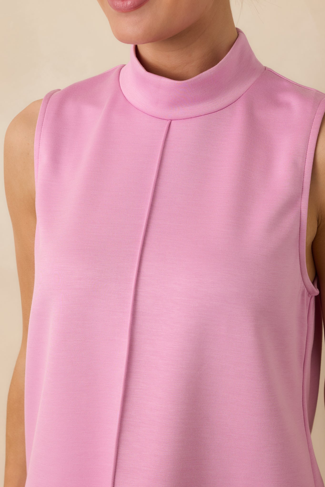 Detailed view of the pink tank top showing the mock neckline, center front seam, and smooth fabric finish.
